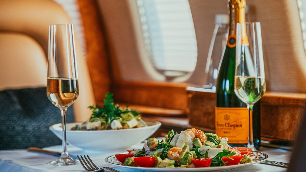 ジェット機の中で豪華な食事を楽しむ様子