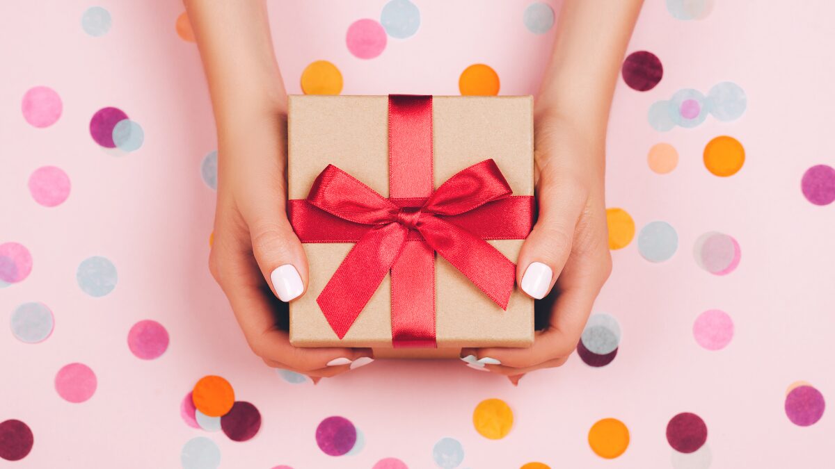 赤いリボンをかけたプレゼントBOXを持つ女性