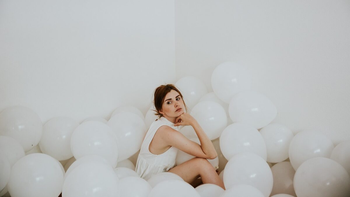白い風船の中に座り込む女性。