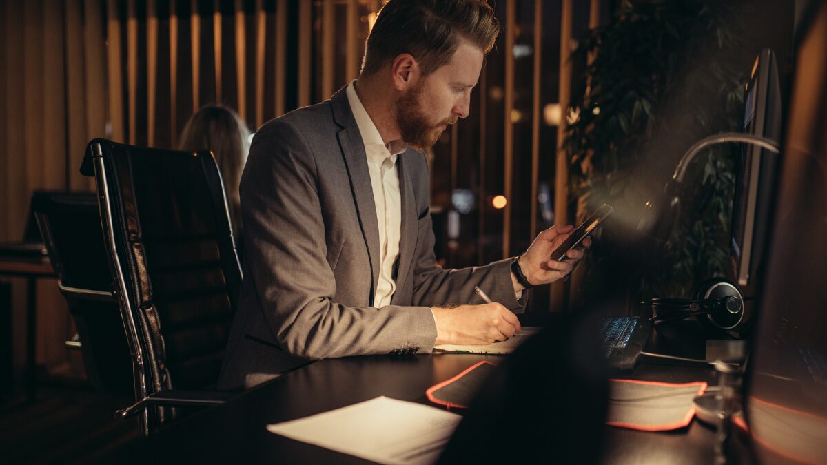 机に向かって仕事をする男性の様子