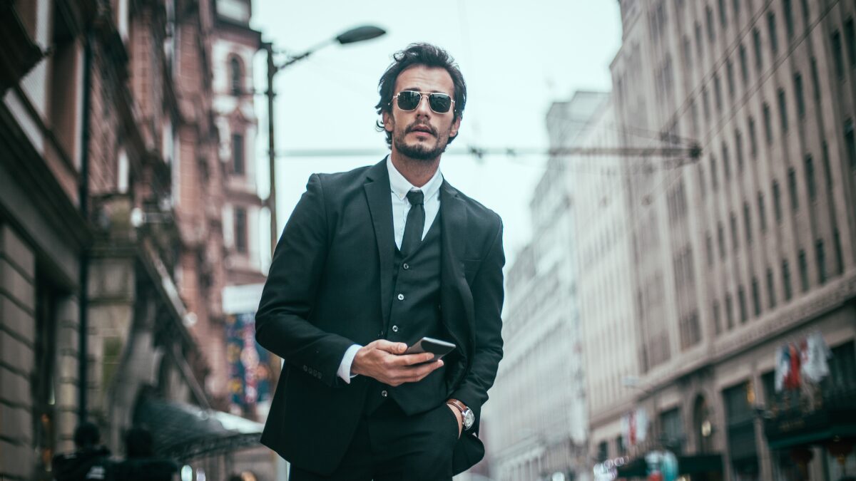 サングラスをしたスーツのダンディな男性が歩いている様子