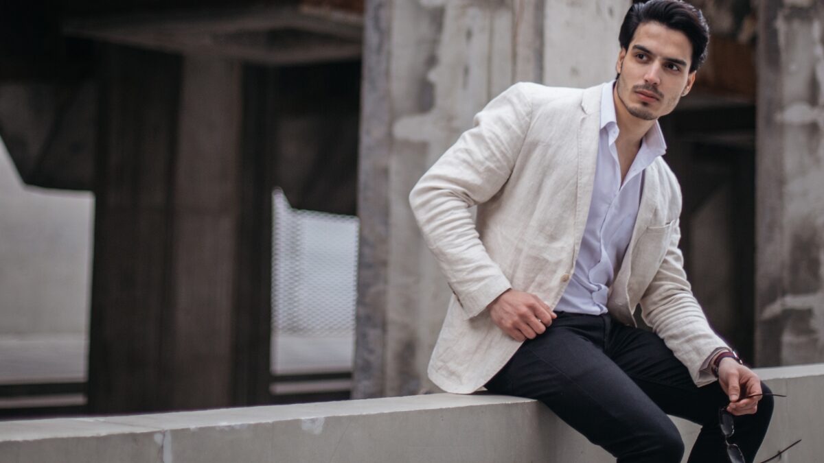 白いジャケットを着た男性が座ってこちらを振り向いている様子