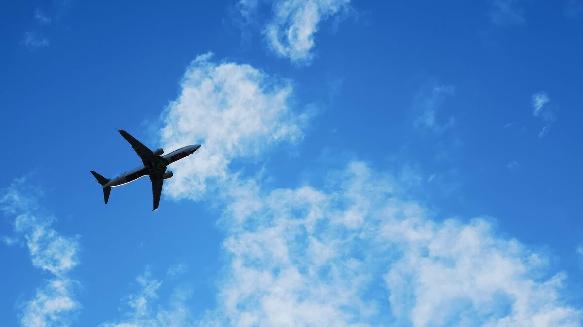 青空を飛行機が飛んでいる様子