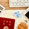 留学にかかる費用を計算しているイメージ画像。スマホや日本のパスポートが置いてある。