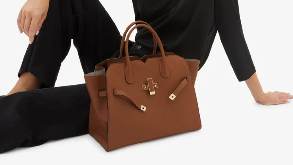 ヴァレクストラのミラノバッグブラウンを横に置いて座っている女性