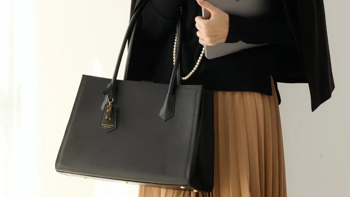 FUMIKODAの黒いバッグを持っているエレガントな女性の画像