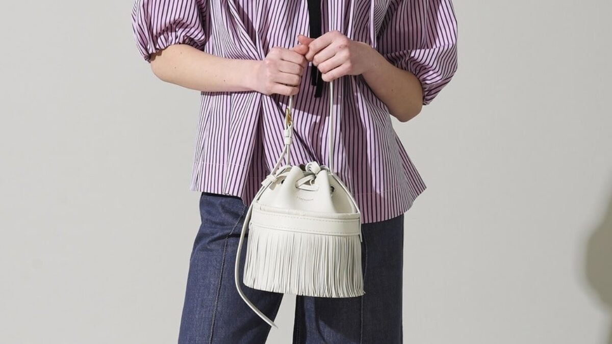 j&m davidsonのシルバーのカーニバルバッグを持っている女性