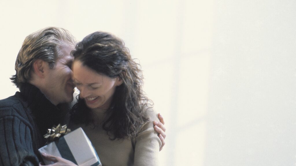 女性が男性にプレゼントを渡して喜んでいる様子