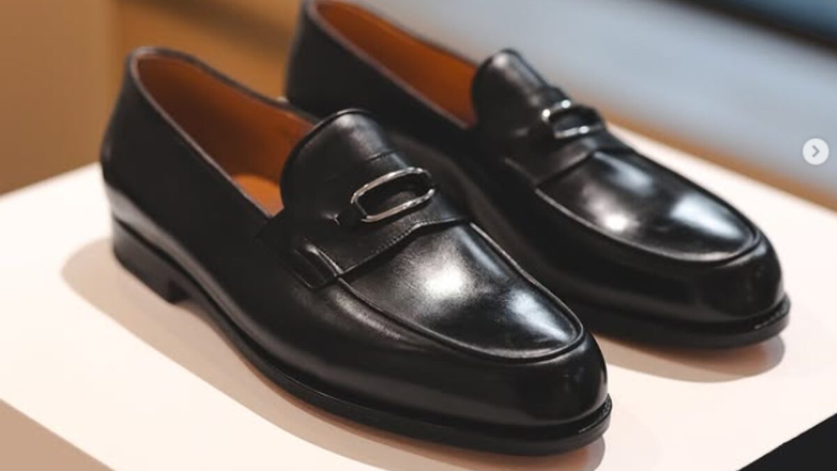 ジョンロブの洗練された黒い革靴が置いてある様子