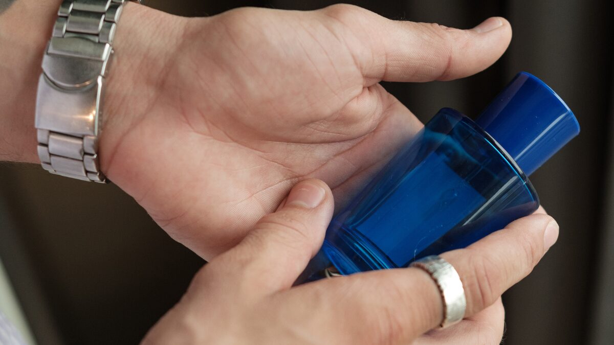 青い香水ボトルを手に持つ様子