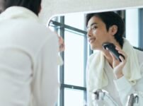 電気シェーバーで髭を剃る男性