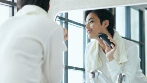 電気シェーバーで髭を剃る男性